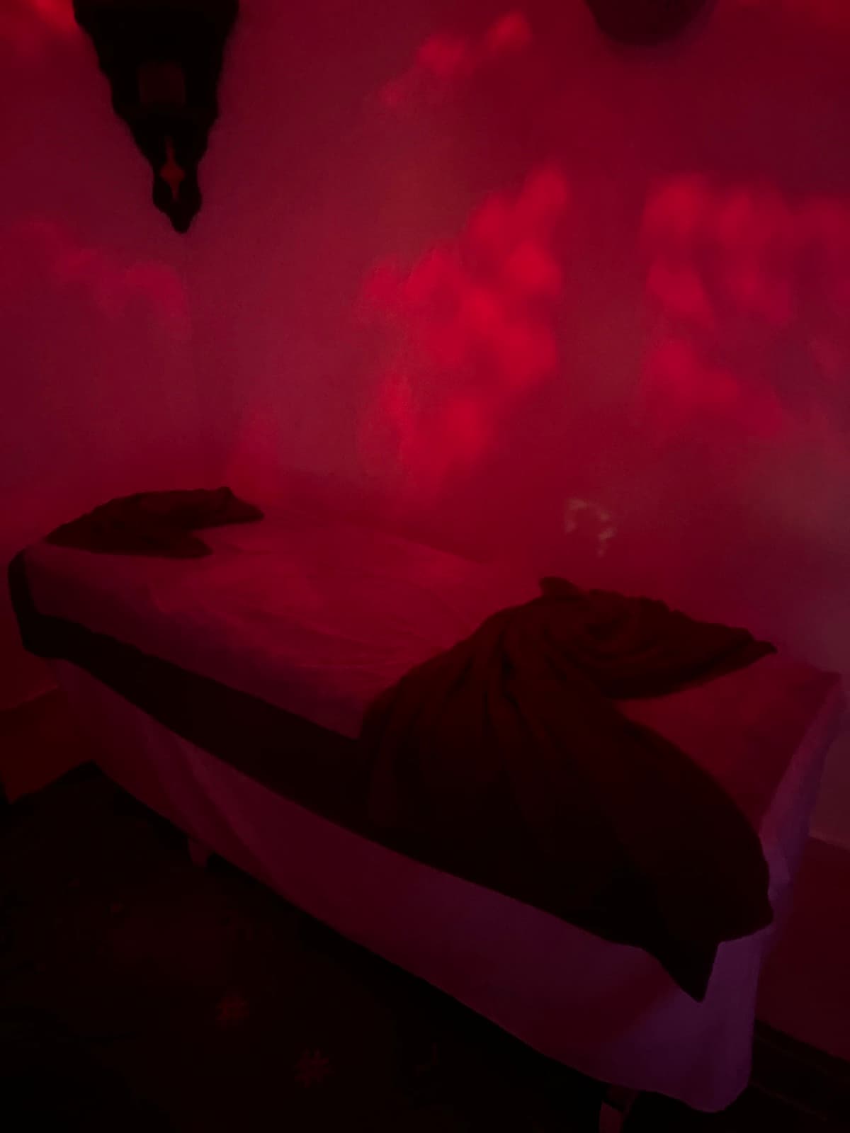 Table de massage drapée de lin et pétales de rose