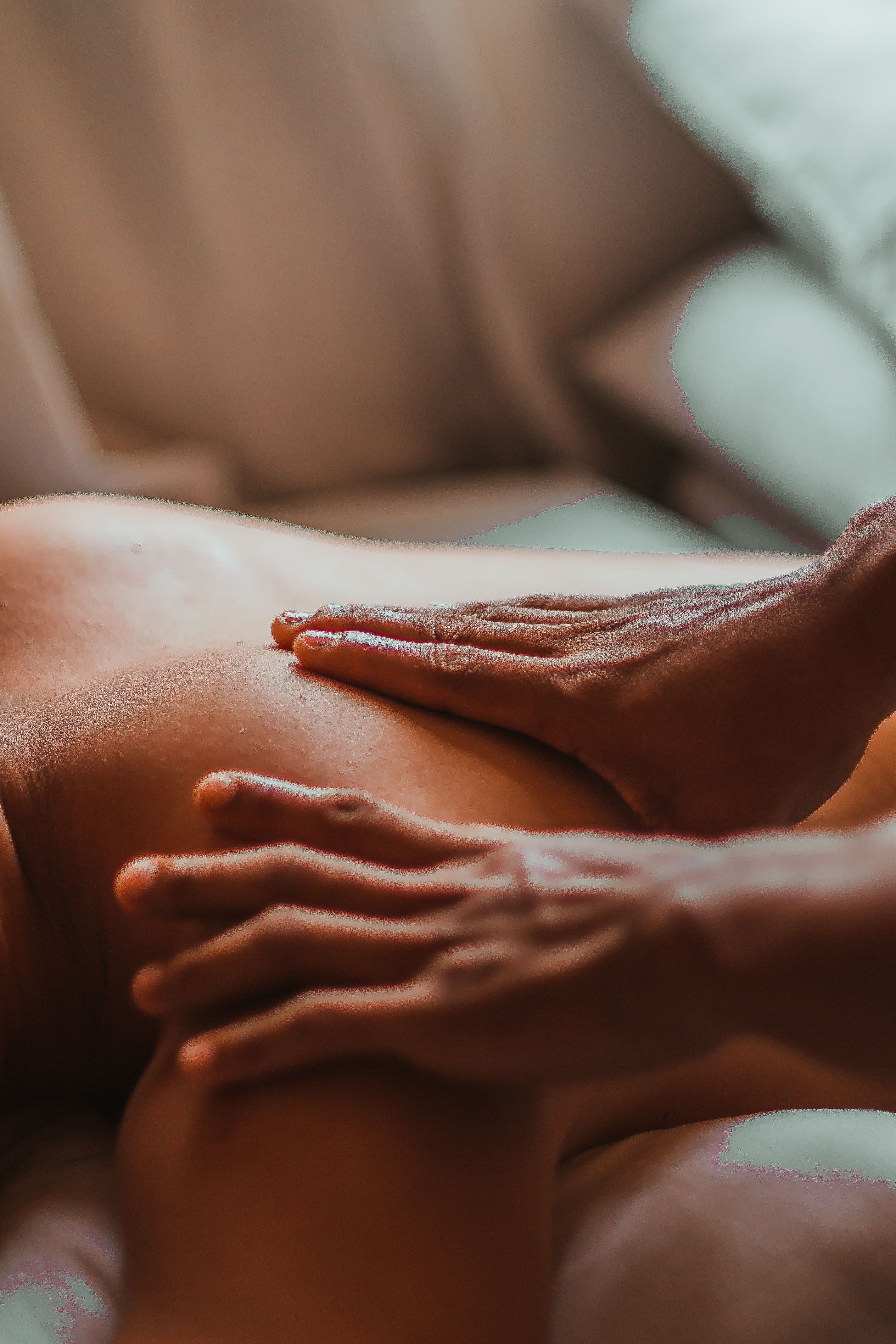 Mains expertes massant le dos, gestes enveloppants et huile chaude